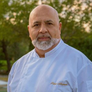 Maestro Fabio Albanesi, pluricampione italiano ed europeo di panificazione e docente del corso panettiere all’Agenzia Formativa Dante Alighieri, in giacca da panificatore bianca.