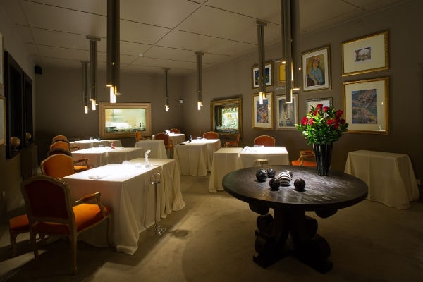 Sala elegante del ristorante Casa Vissani con tavoli apparecchiati, quadri alle pareti e atmosfera intima e raffinata.