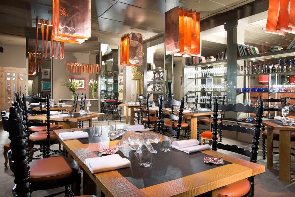 Sala ristorante di Casa Vissani con arredi moderni, tavoli apparecchiati e lampade di design sospese.