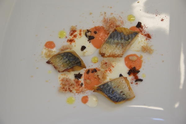 Filetti di pesce su crema bianca e salsa rossa con guarnizione di polvere e gocce di olio extravergine, piatto gourmet dello chef Fabrizio Ferrari.