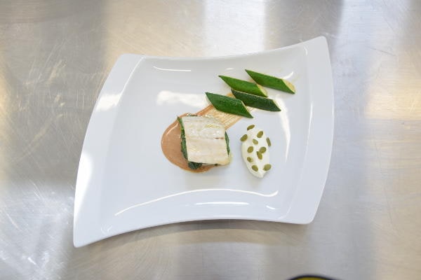 Filetto di pesce con crema di verdure, semi e contorno di fagiolini verdi, piatto elegante preparato dallo chef Fabrizio Ferrari.