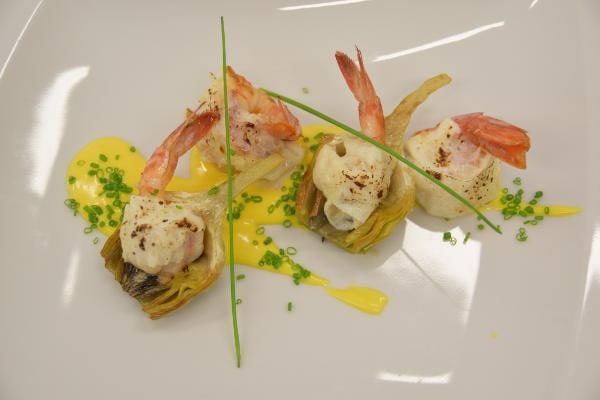 Gamberi con mousse e carciofi su salsa gialla, piatto gourmet creativo firmato dallo chef Fabrizio Ferrari.