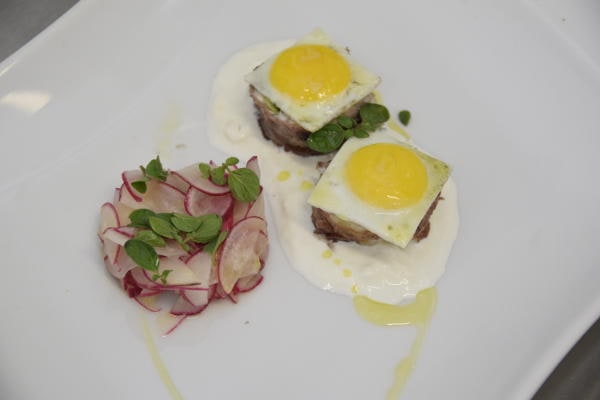 Uova al tegamino su carne con insalata di ravanelli, piatto creativo dello chef Gionata Bignotti.