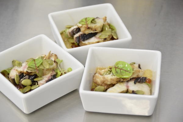 Tris di ciotoline con piatti gourmet a base di pesce, semi croccanti e germogli, firmati dallo chef stellato Gionata Bignotti.