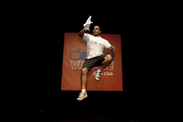 Giuseppe Lapolla, maestro pizzaiolo pluricampione del mondo, durante una spettacolare esibizione di pizza freestyle sul palco.